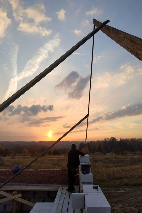 The Masonry Mooring the Wall in the Fresh Air with a Trowel and Glue