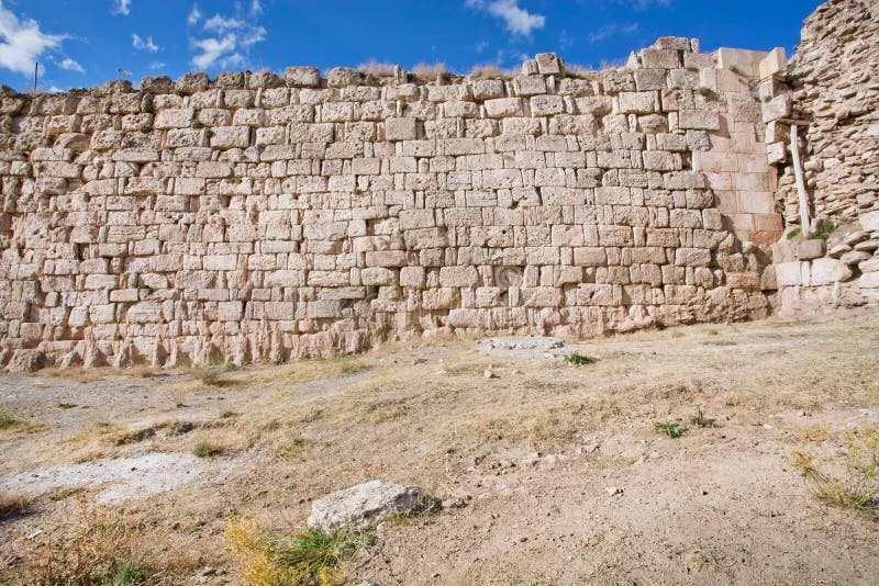 Masonry wall of city fortification with bricks of different size and texture ander blue sky in the historical valley of East