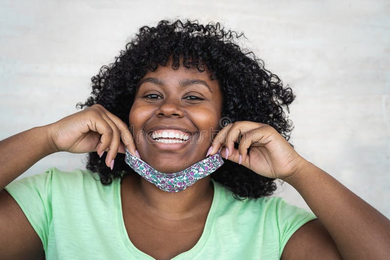 Happy Afro woman portrait - African girl wearing face mask smiling in front of camera - Health care and corona virus outbreak concept. Happy Afro woman portrait - African girl wearing face mask smiling in front of camera - Health care and corona virus outbreak concept