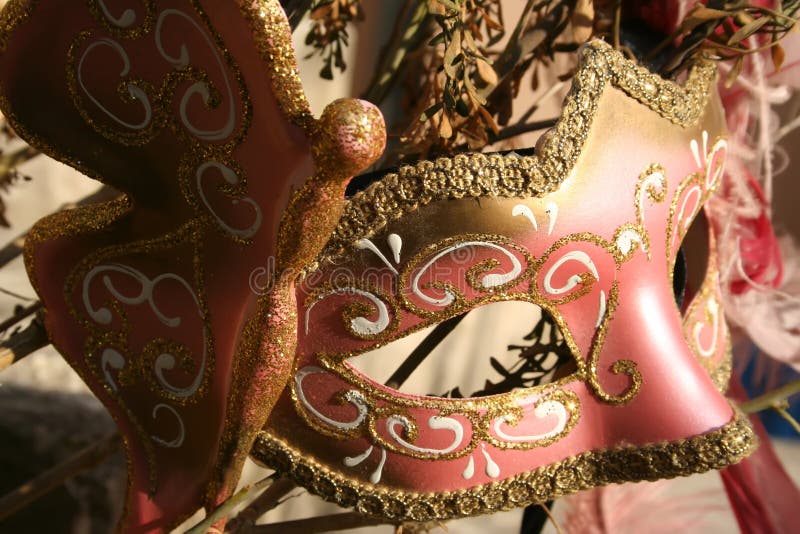 Pink masquerade mask with gold details.