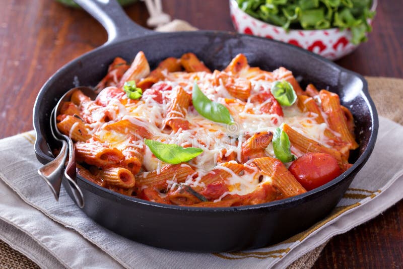 A massa coze com penne, tomates e mozarella fotografia de stock A massa coze com penne, tomates e mozarella fotografia de stock