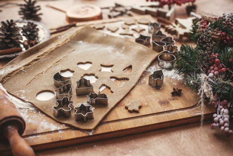 Massa das cookies do pão-de-espécie do Natal com os cortadores do metal em rústico