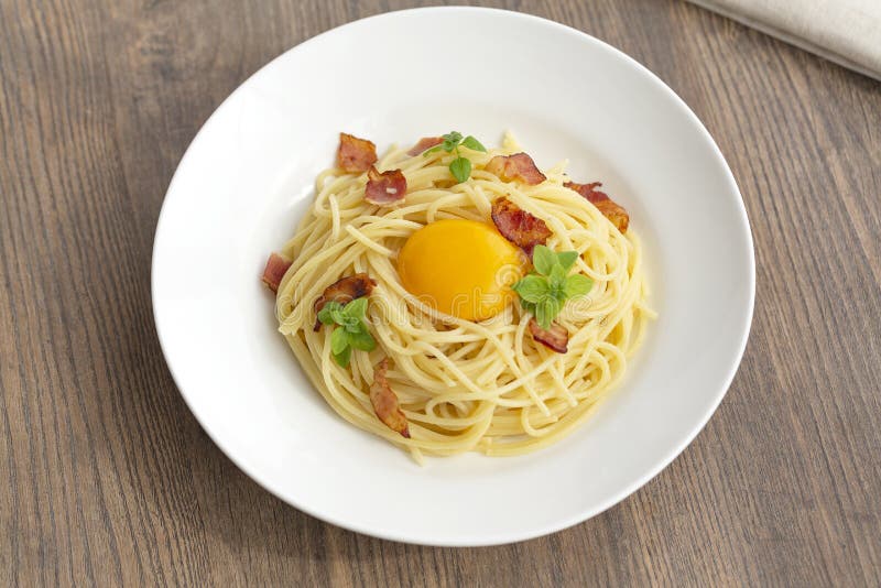 Massa de Carbonara, espaguetes com pancetta, ovo, molho duro do queijo parmesão, da manjericão e de creme fotografia de stock royalty free Massa de Carbonara, espaguetes com pancetta, ovo, molho duro do queijo parmesão, da manjericão e de creme fotografia de stock royalty free