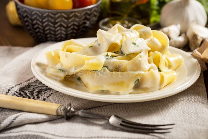 Fine Pappardelle Pasta with White Creamy Alfredo Sauce on Dark Wooden Table. Fine Pappardelle Pasta with White Creamy Alfredo Sauce on Dark Wooden Table
