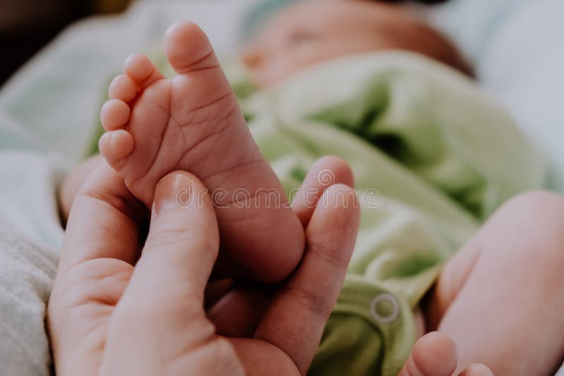 Massage of baby`s feet. Mother`s hand touching tiny newborn baby feet. stock photography