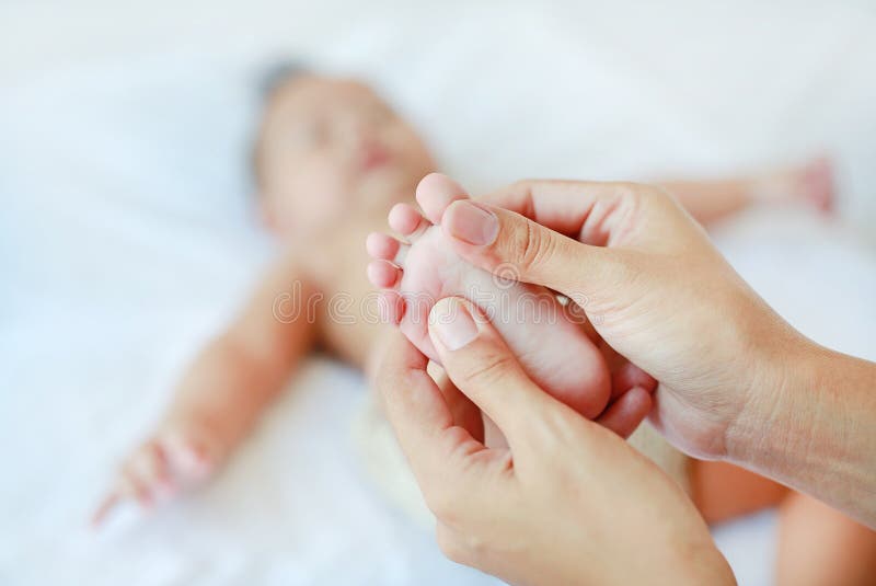 Massage en gros plan de pied de bébé sur le lit photo stock Massage en gros plan de pied de bébé sur le lit photo stock