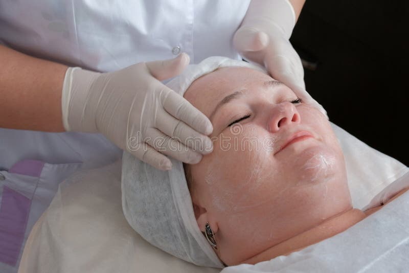 Massage facial thérapeutique et cosmetological d'une grosse femme Les mains d'un esthéticien professionnel dans les gants médi photo stock Massage facial thérapeutique et cosmetological d'une grosse femme Les mains d'un esthéticien professionnel dans les gants médi photo stock
