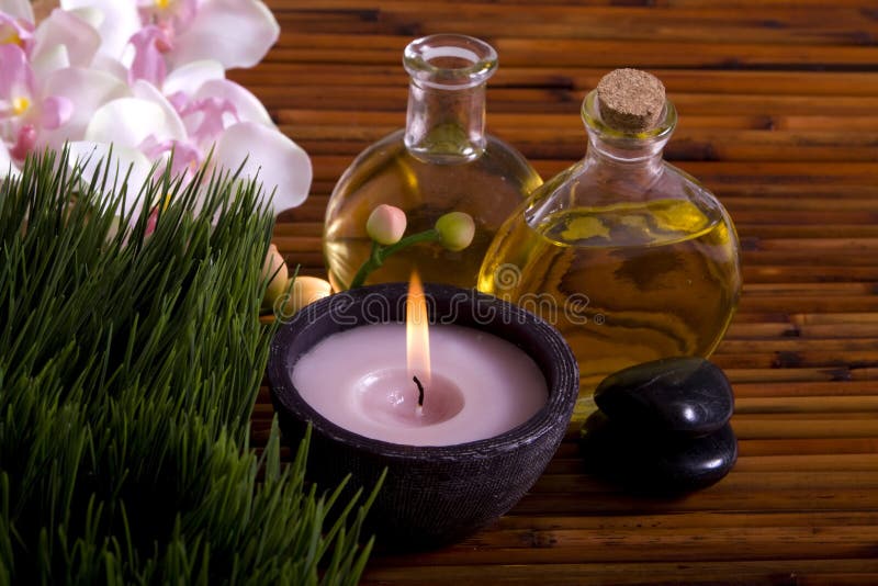 Massage oils, orchid flower, pebbles on bamboo stock images