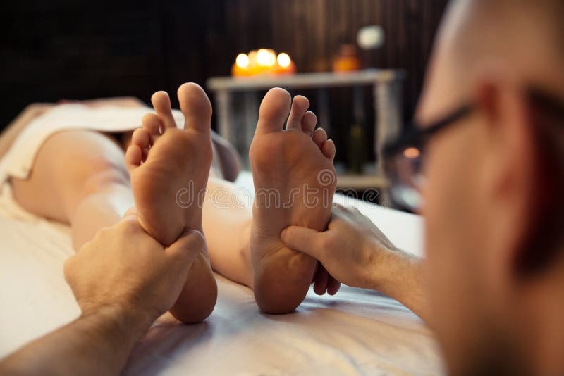 Massage therapist doing a woman`s foot massage