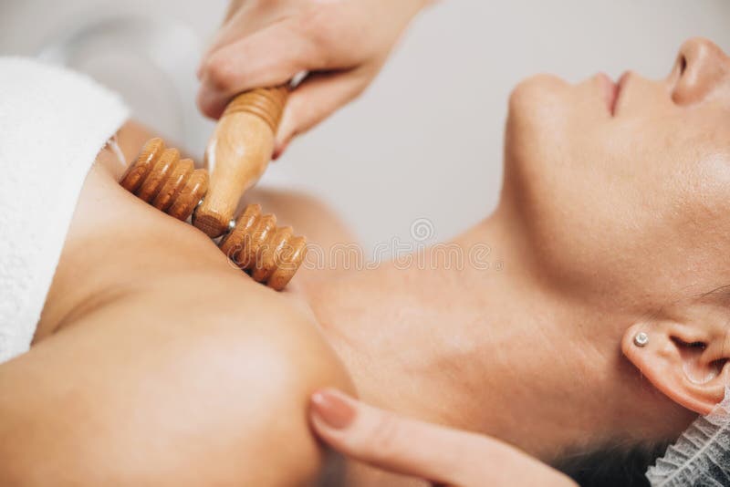 Massagebehandeling tegen massage bij maderotherapie bij vrouwen decolletage en nek met houten rollen