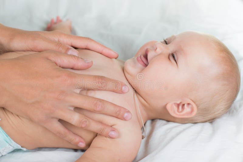 Massagem do bebê Mãe que faz massagens a barriga infantil
