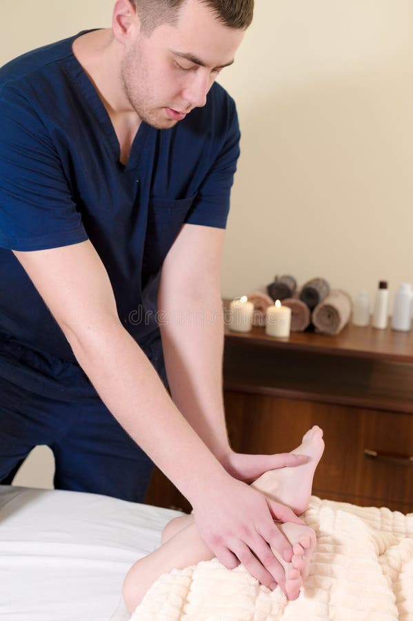 Massagens manuais masculinas e estiramentos de um terapeuta profissional da massagem os pés e os pés do paciente da criança pé imagens de stock Massagens manuais masculinas e estiramentos de um terapeuta profissional da massagem os pés e os pés do paciente da criança pé imagens de stock