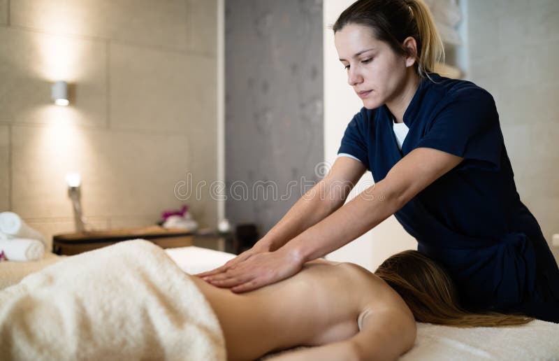 Massaggiatore che massaggia indietro della femmina fotografia stock Massaggiatore che massaggia indietro della femmina fotografia stock