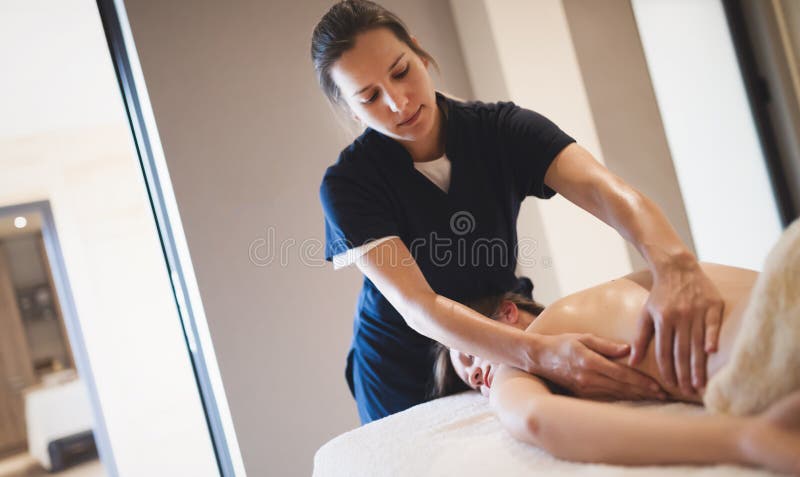 Massaggiatore che massaggia indietro della femmina immagini stock libere da diritti Massaggiatore che massaggia indietro della femmina immagini stock libere da diritti