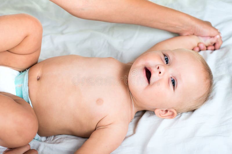 Massaggio del bambino Madre che massaggia pancia infantile immagine stock Massaggio del bambino Madre che massaggia pancia infantile immagine stock