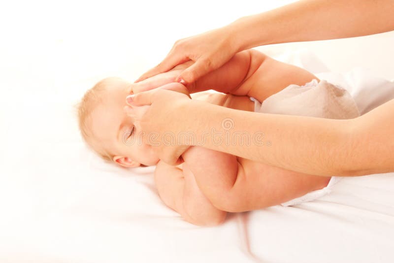 Massaggio del bambino Piedi del bambino che toccano la sua fronte fotografie stock Massaggio del bambino Piedi del bambino che toccano la sua fronte fotografie stock