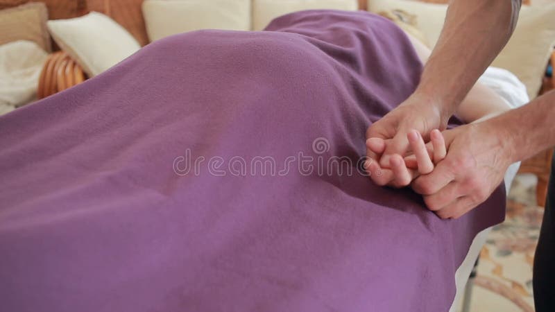 Massagista masculino que faz a massagem da mão para mulheres