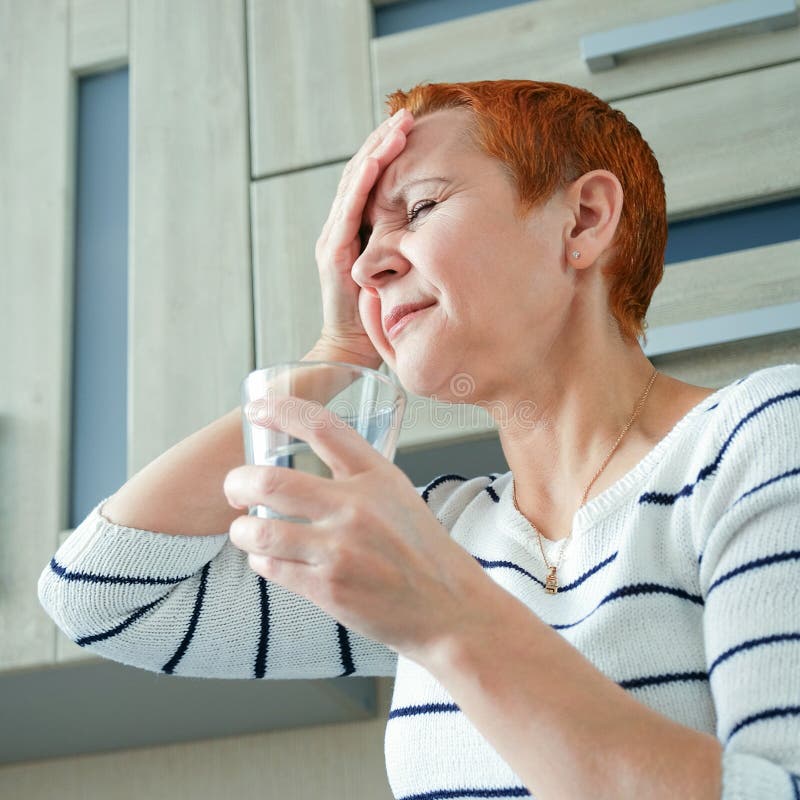 Masseer zijn tempels Een vrouw die aan een hoofdpijn lijden Gezondheidsproblemen, Vrouw die haar hoofd met haar hand houden stock afbeeldingen Masseer zijn tempels Een vrouw die aan een hoofdpijn lijden Gezondheidsproblemen, Vrouw die haar hoofd met haar hand houden stock afbeeldingen