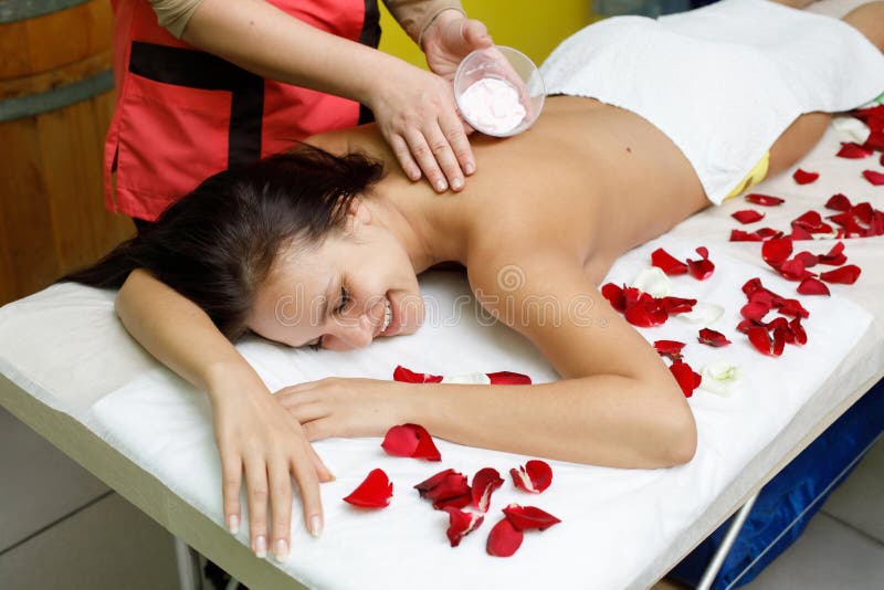 Rose massage. Массаж розами. Цветы розы массаж. Девушка раздевается на массажном столе спа процедуры. Моделирующий массаж с розовыми лепестками.