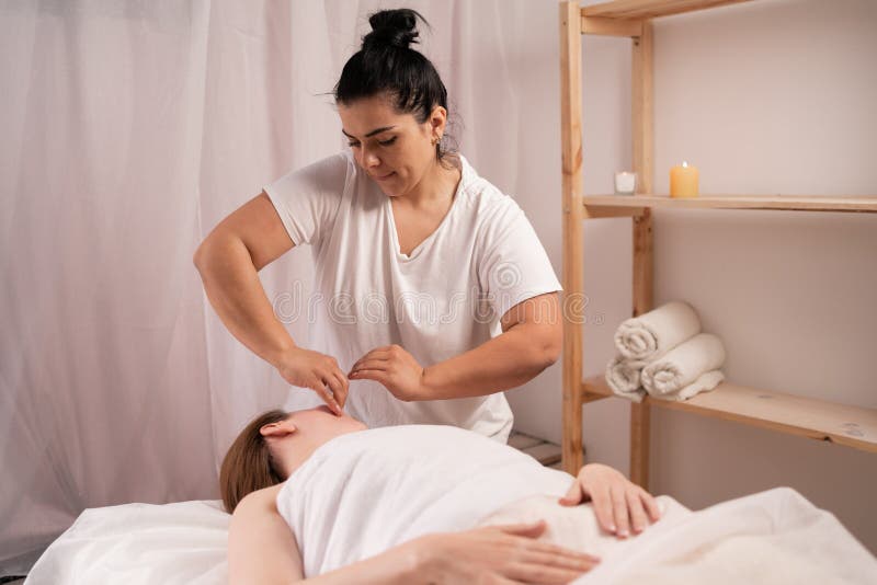 Masseur Doing Massage Face And Head Of Young Woman In Spa Salon Skincare And Beauty Stock Image