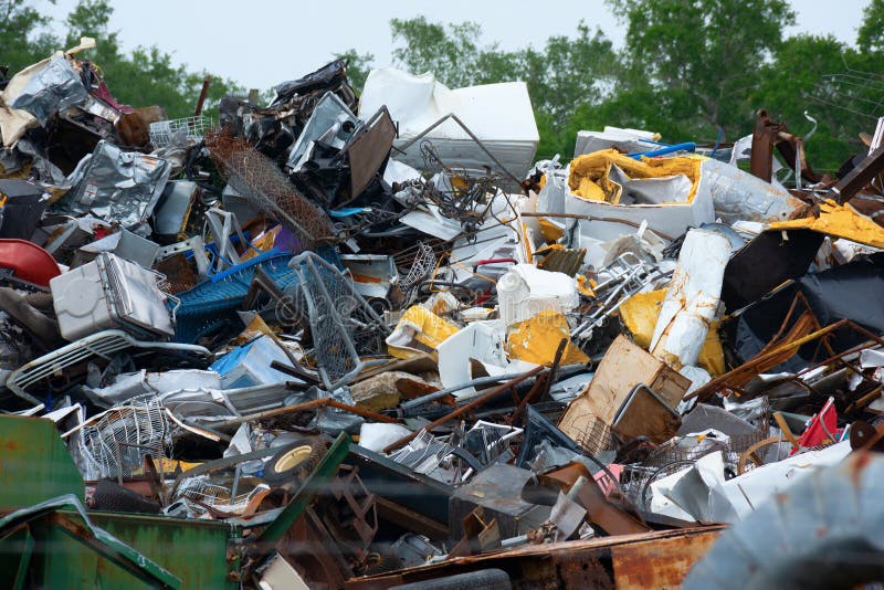 Massive junk yard pile of diverse trash of metal containers fencing insulation and cabinets