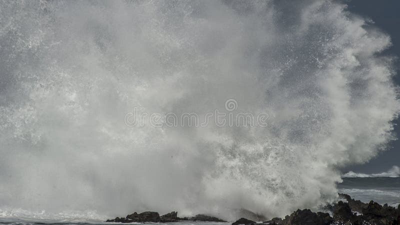 Massive Wave Brkes on Rocks. A massive wave explodes and disintergrates as it brakes on the shoreline stock photography Massive Wave Brkes on Rocks. A massive wave explodes and disintergrates as it brakes on the shoreline stock photography