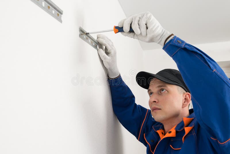 The Master Attaches the Iron Plates To the Wall with a Screwdriver