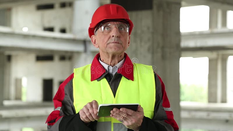 Master builder with tablet PC at construction site