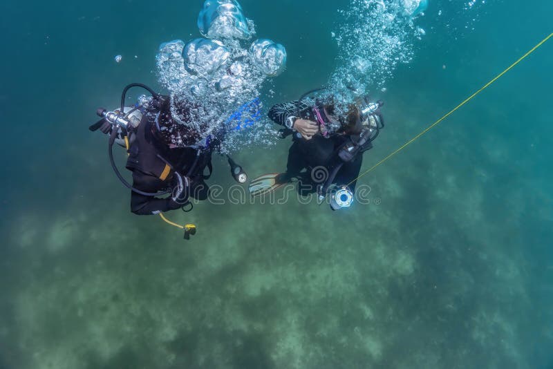 Master Diver and Dive Pupil Preparing To Ascend after Dive Training at