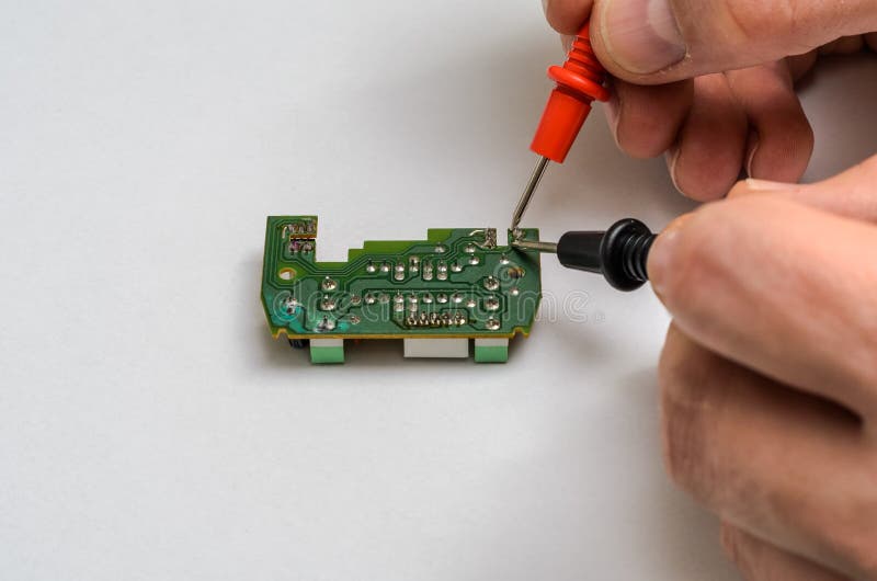 Master engineer tests and repairs microchip with multimeter stock images Master engineer tests and repairs microchip with multimeter stock images