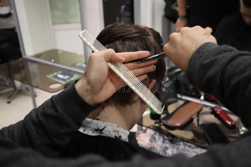 Master hairdresser does hairstyle and style with scissors and comb. Master stacks hair of men in barbershop, hairdresser makes hai royalty free stock photo Master hairdresser does hairstyle and style with scissors and comb. Master stacks hair of men in barbershop, hairdresser makes hai royalty free stock photo