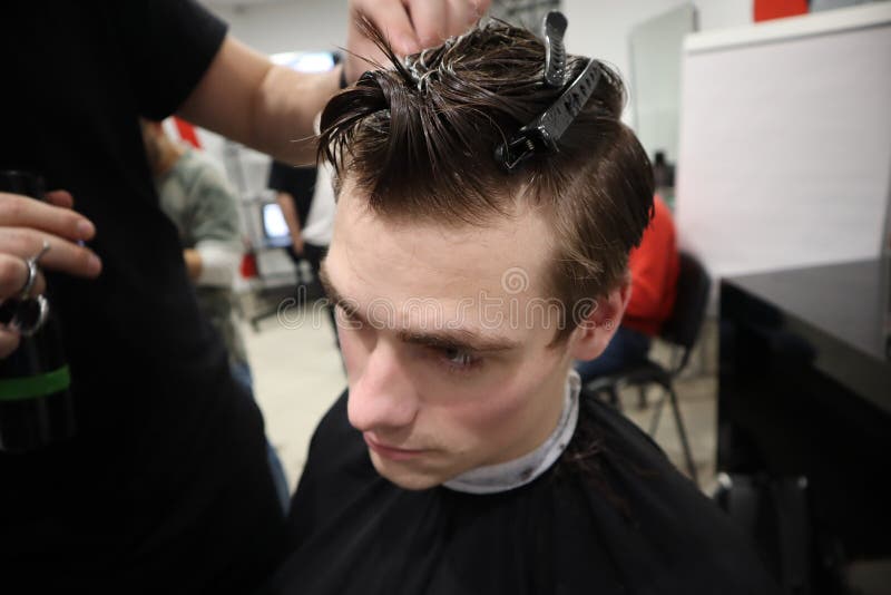 Master hairdresser does hairstyle and style with scissors and comb. Master stacks hair of men in barbershop, hairdresser makes hai royalty free stock image Master hairdresser does hairstyle and style with scissors and comb. Master stacks hair of men in barbershop, hairdresser makes hai royalty free stock image