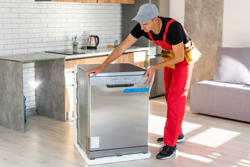 Master Installing the Dishwasher in a Kitchen Stock Photo