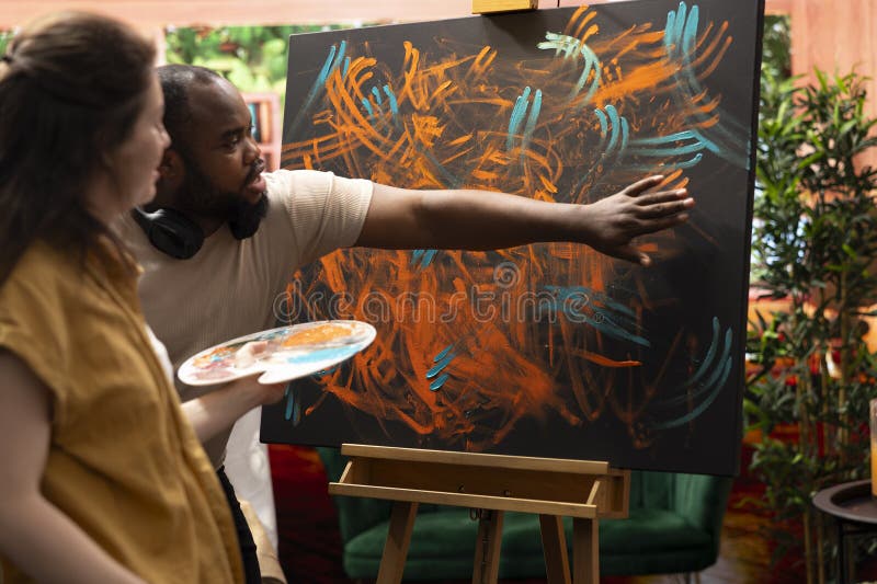 Master painter and apprentice creating a masterpiece with finger paint royalty free stock photo