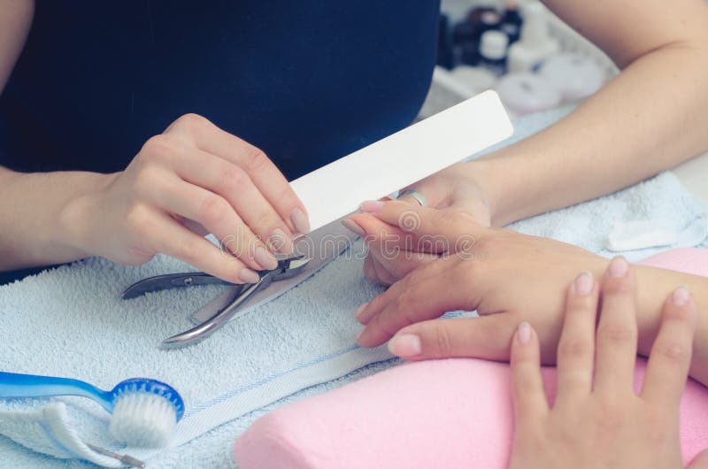 The master prepares the nails for manicure stock photography The master prepares the nails for manicure stock photography