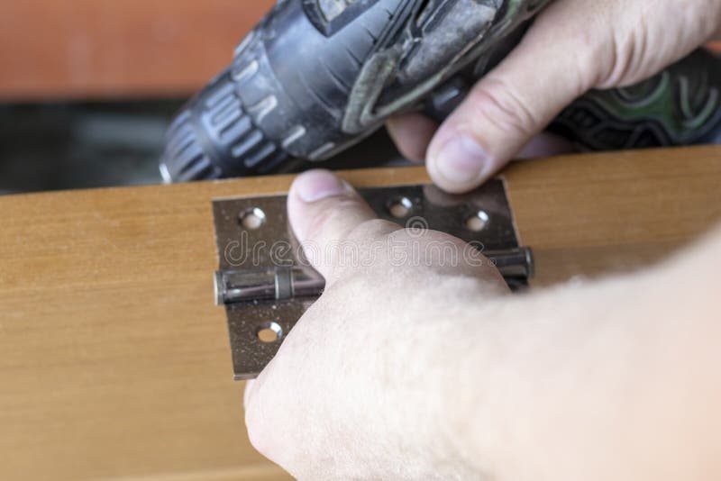 The Master Sets The Door Hinge Drills A Hole With A Tool Stock