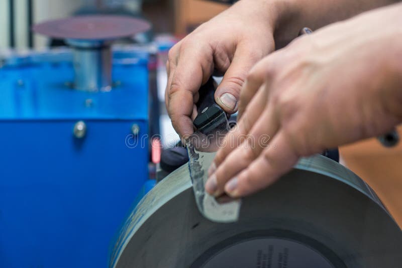 Master Sharpening a Knife with a Black Handle for Grinding Machine