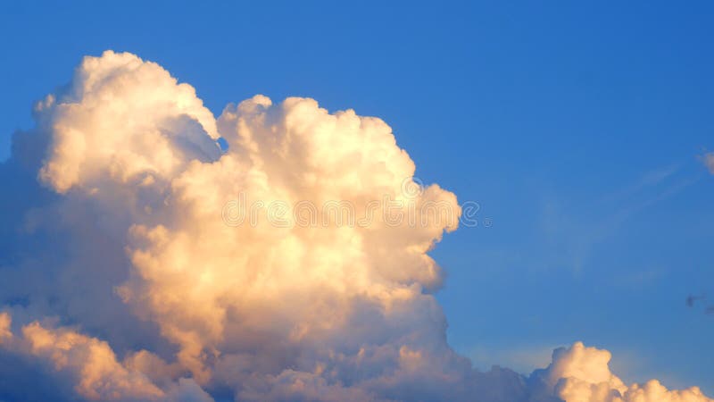 Masywne chmury cumulus congestus lub kumulus wędrują powoli przez niebo pięknie oświetlone przez