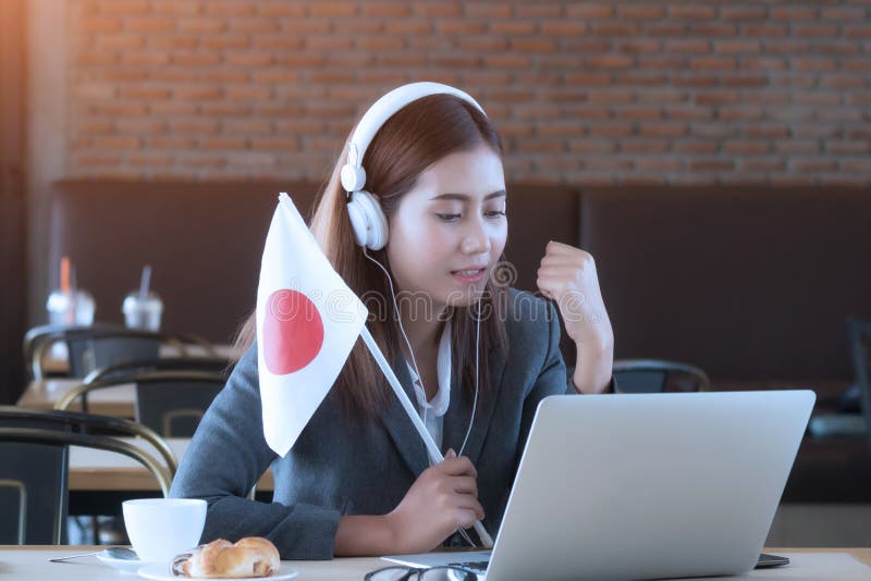 Match en ligne de écoute de jeune femme d'affaires asiatique, te du Japon d'acclamation images libres de droits Match en ligne de écoute de jeune femme d'affaires asiatique, te du Japon d'acclamation images libres de droits