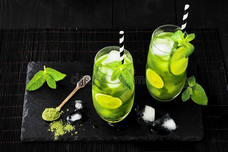 Matcha bevroor groene thee met kalk en verse munt op de zwarte achtergrond van de steenlei Super voedseldrank royalty-vrije stock afbeelding Matcha bevroor groene thee met kalk en verse munt op de zwarte achtergrond van de steenlei Super voedseldrank royalty-vrije stock afbeelding
