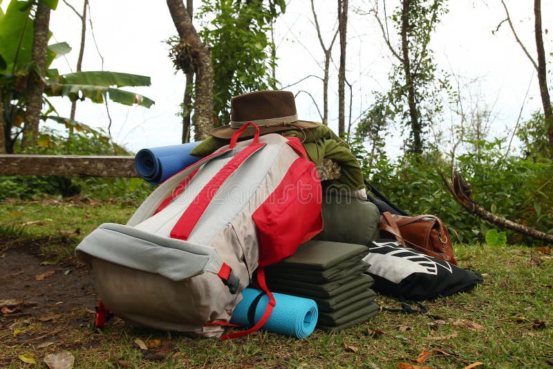 Materiaal om op een gras te kamperen - de rugzak, de tent, de slaapzakken, de matten en andere vullen voor het comfortabele het k royalty-vrije stock foto Materiaal om op een gras te kamperen - de rugzak, de tent, de slaapzakken, de matten en andere vullen voor het comfortabele het k royalty-vrije stock foto