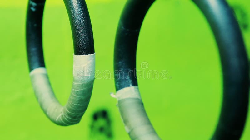 Material de cierre de los anillos de gimnasia colgados en el fondo verde borroso almacen de video