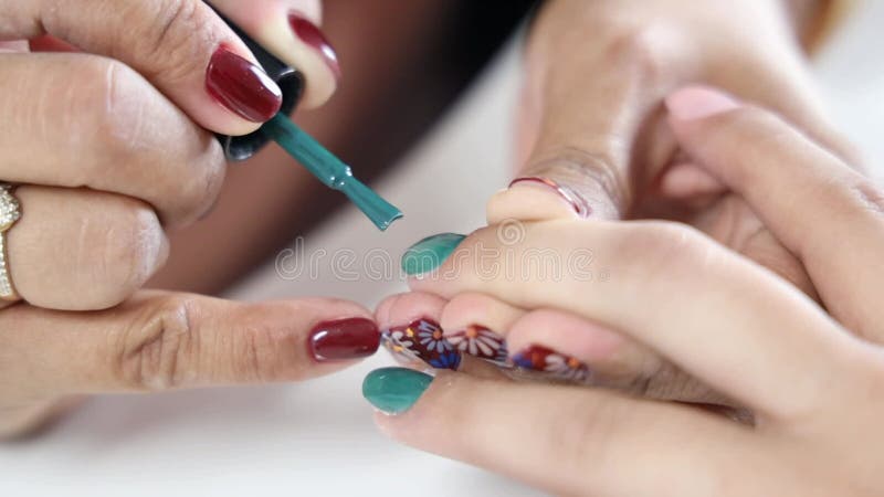 Material de cierre de manos de mujeres mientras ella está pintando las uñas de una mujer almacen de video