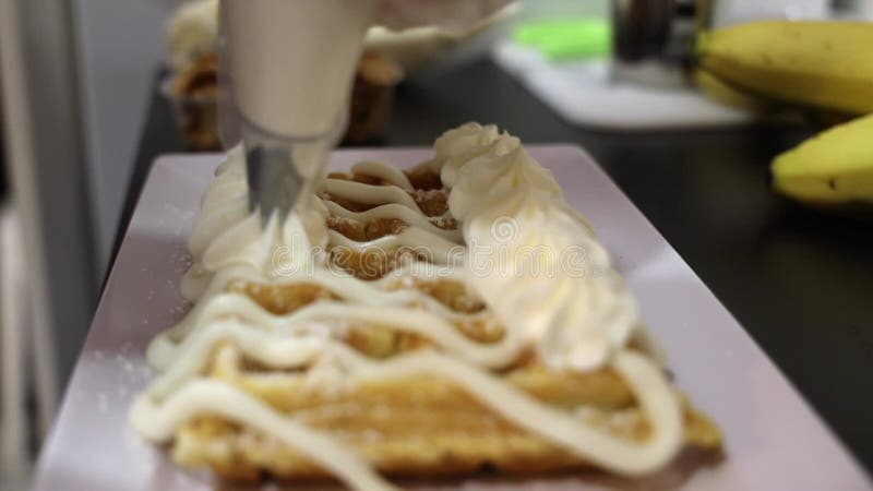 Material de clausura de poner crema de látigo en el Waffle fresco en la bandeja blanca almacen de metraje de vídeo