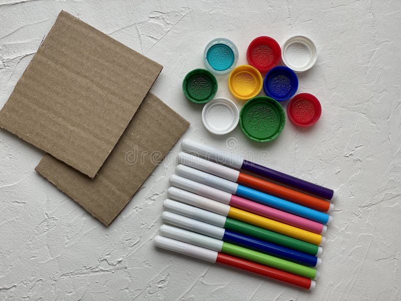 The material for kid creativity is cardboard markers and plastic lids royalty free stock photo