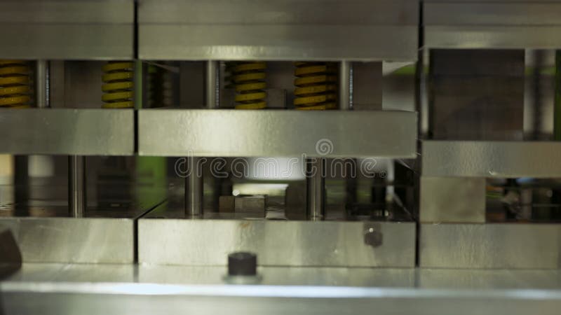 Materiale di chiusura di una macchina per pressare i metalli con molle gialle durante il lavoro in fabbrica stock footage