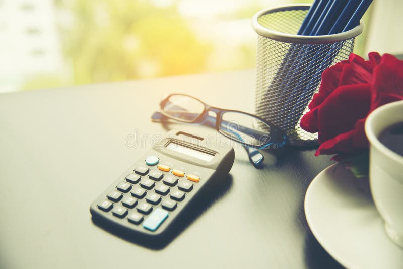 Materiales de negocios con lápiz, calculadora, rosa roja, taza de café, papel de oficina imagen de archivo Materiales de negocios con lápiz, calculadora, rosa roja, taza de café, papel de oficina imagen de archivo