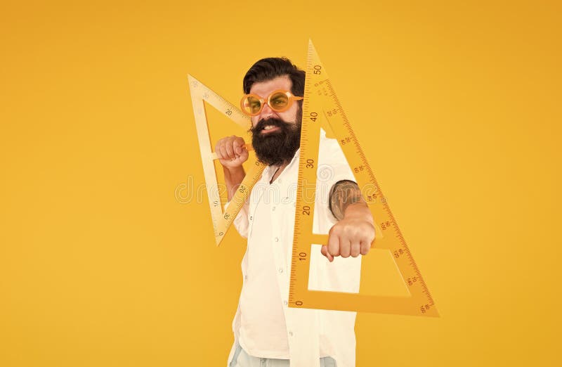 Math genius. Geometry geek holding triangles on yellow background. Geek or nerdy student making angle. Bearded man in