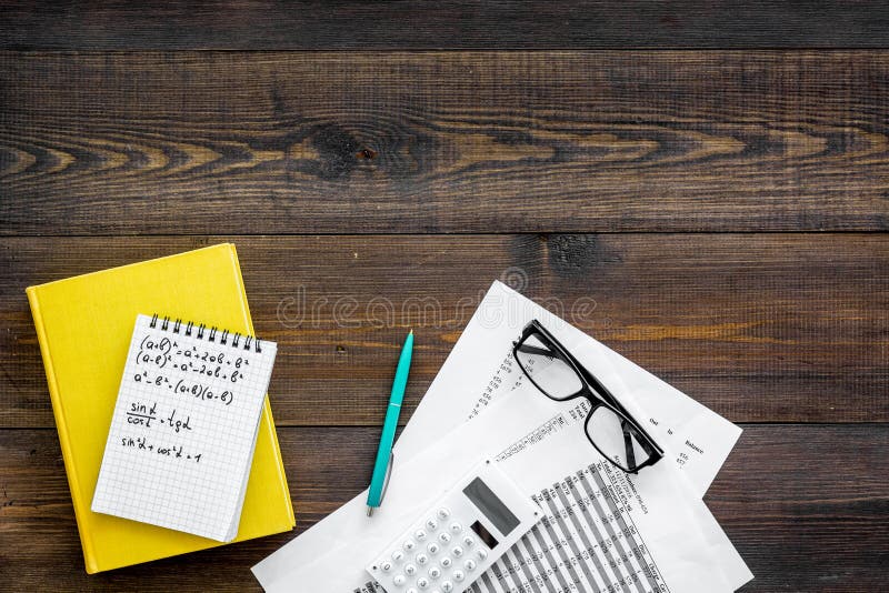 Math homework. Math textbook or tutorial near sheet with numbers, countes, calculator, notebook with formula on dark stock photography