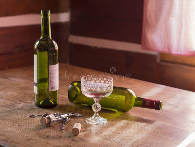 Matin après les bouteilles vides de la beuverie deux de vin rouge et de verre t photographie stock Matin après les bouteilles vides de la beuverie deux de vin rouge et de verre t photographie stock